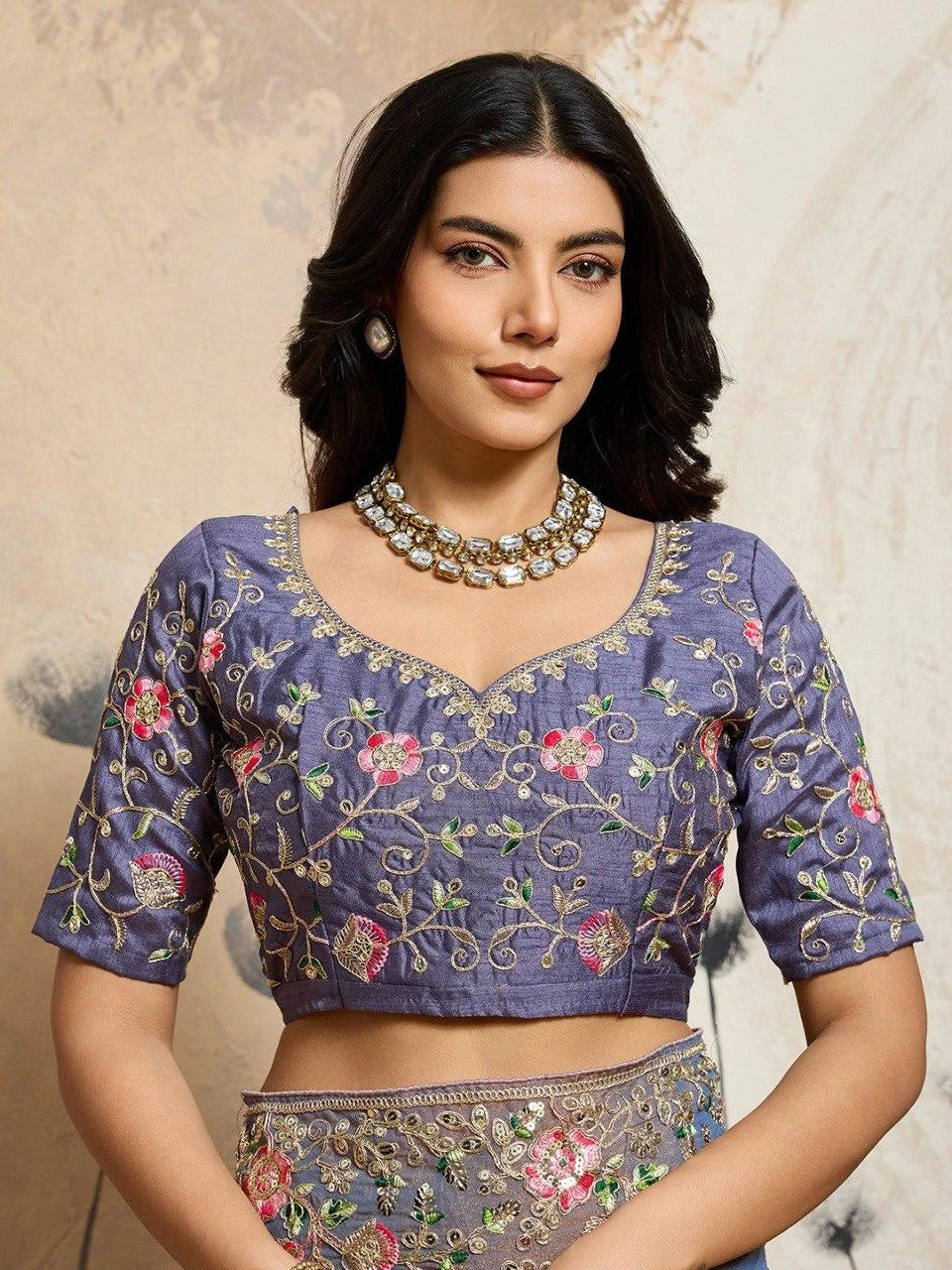 Woman wearing a traditional embroidered blouse with a neutral background